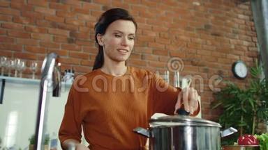 女人在厨房做汤。 女孩在<strong>煮锅</strong>里加盐。